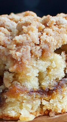 a close up of a piece of cake on a wooden board with crumbs