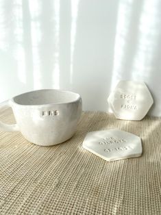 a white bowl sitting on top of a table next to two coasters that say best place