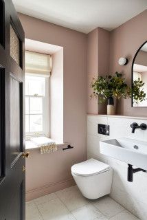 a white toilet sitting next to a bathroom sink under a large mirror on top of a wall