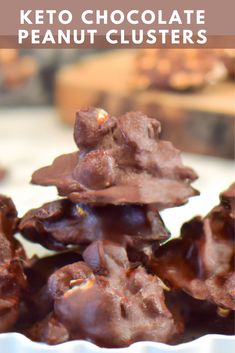 keto chocolate peanut clusters stacked on top of each other in a white bowl with text overlay