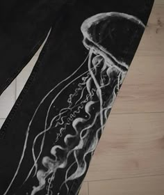 a pair of black jeans with a drawing of a jellyfish on the bottom and side