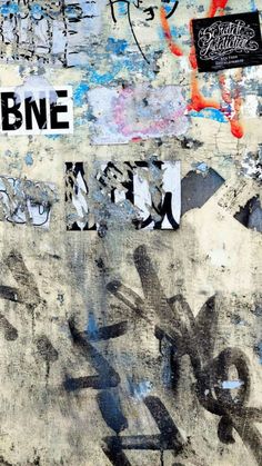 a wall covered in graffiti and stickers with the word bne on it's side