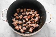 some meat is cooking in a pot on the table