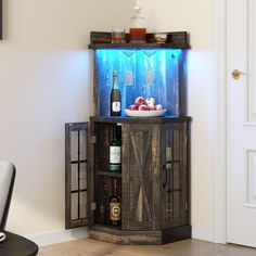 a wooden cabinet with wine bottles on top and an aquarium in the bottom, next to a chair