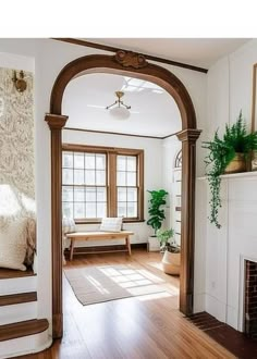 a living room filled with furniture and a fire place in the middle of a wooden floor