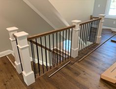 an empty room with hard wood flooring and white bannister railings on the second floor