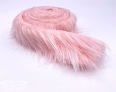 a roll of pink fur sitting on top of a white surface