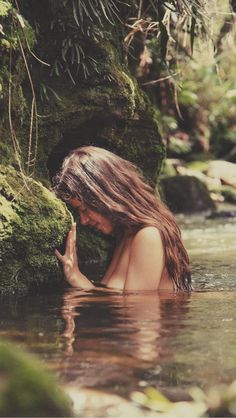 a woman in the water with her hands together