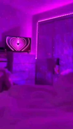 a bedroom with purple lighting and a heart on the wall