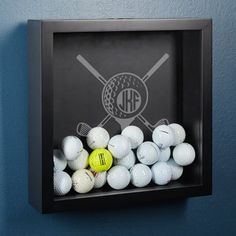 a shadow box with golf balls in it and a monogrammed ball on the bottom