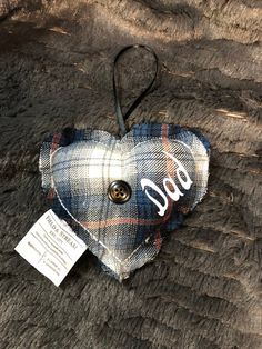 a plaid heart shaped ornament with the word god on it hanging from a cord