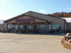 an antique store with hay bales and pumpkins in the foreground on a sunny day