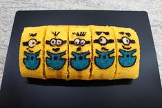 there are five cookies decorated to look like minion's on the black plate