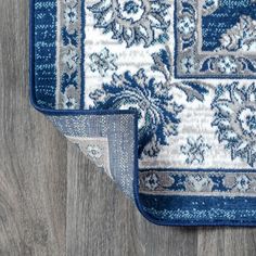 two blue and white rugs laying on top of a wooden floor next to each other