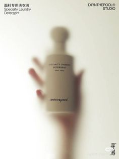 a blurry photo of a person's hand holding a bottle with the words disintement laundry on it