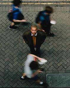 an overhead view of people walking down the street with one man wearing a suit and tie