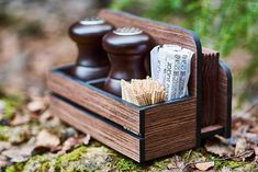 two wooden judges in a holder on top of mossy ground with leaves and twigs