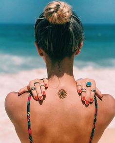 the back of a woman's neck with rings on it