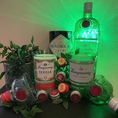 several bottles and glasses are sitting on a table next to a potted green plant