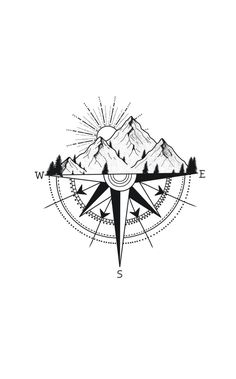 a black and white compass with mountains in the background