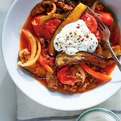 a white bowl filled with meat and vegetables