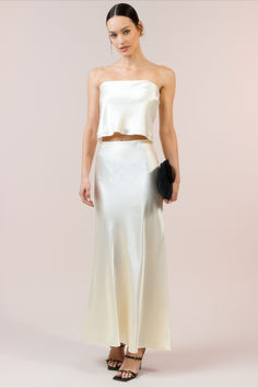 Expertly crafted for comfort and elegance, the Skylar Silk Skirt boasts a maxi length of luxurious silk. Done with dreamy softness and flowy shine, while the easy elastic waist ensures a perfect fit every time. Elevate your style with this must-have piece. White Satin Skirt, Calypso Dress, Long Silk Skirt, White Skirt Outfits, Halter Bridesmaid Dress, Silk Maxi Skirt, Bridal Tops, Hip Style, Silk Maxi