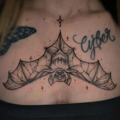 a woman's chest with a bat tattoo on it that says eigerer