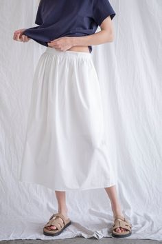 Lighten up your wardrobe with the Rora Poplin Skirt! This playful midi skirt features an elasticated waistband for comfort, a hidden zipper for a seamless look, and pockets for added functionality. Lightweight and stylish, it's the perfect addition to your summer wardrobe. Sizing: Model is 5'8", wearing a size S Content: 100% Cotton Care: Handwash recommended Nomad Clothing, Poplin Skirt, Sweater Crop, Dress Home, Long Skirts, Tank Top Long Sleeve, Crop Top Sweater, Loungewear Sets, Floral Dress Summer