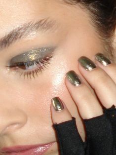 a close up of a woman with her hands on her face and eyeliners