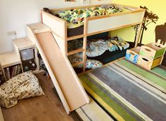 a child's bedroom with bunk beds and slide in the corner, on top of carpeted flooring