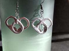 the earrings are shaped like two interlocked hearts