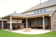 an outdoor patio with grill and seating area in the back yard, surrounded by grass