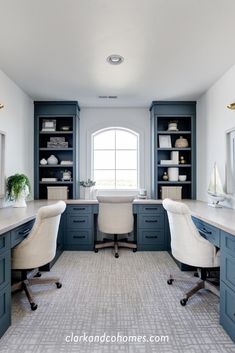 an office with two desks and chairs in the middle of it, surrounded by built - in bookshelves