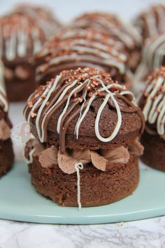 chocolate desserts with white frosting and sprinkles on a blue plate