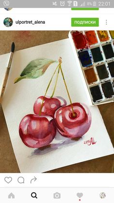 a painting of three cherries on paper next to a brush and watercolor palette