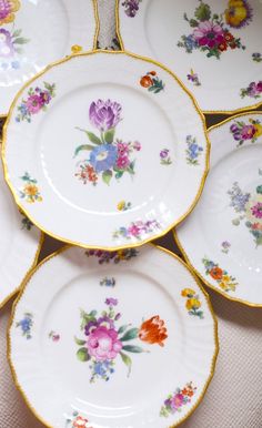 several plates with flowers on them are stacked up next to each other in the same pattern