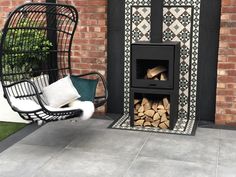 a chair sitting next to a fire place in front of a brick wall