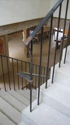 there is a metal handrail on the stairs in this house with white walls and flooring