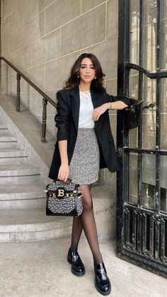 a woman is standing on the steps with her handbag