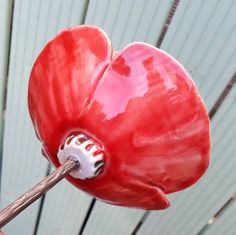 a close up of a red flower with a wrench in it