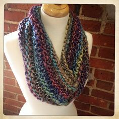 a multicolored crocheted scarf on a mannequin