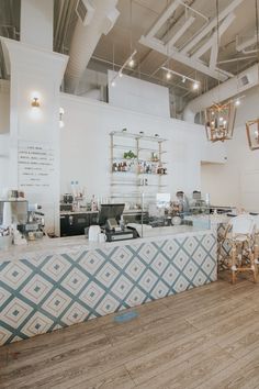 the inside of a restaurant with tables, chairs and lights hanging from the ceiling above