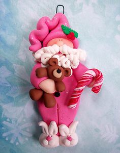 a pink ornament with a teddy bear holding a candy cane