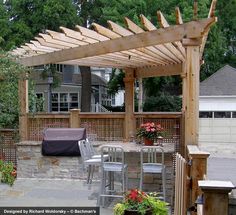 an outdoor patio with table and chairs under a pergolated trellis covered area