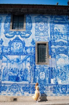 a woman walking past a blue and white building