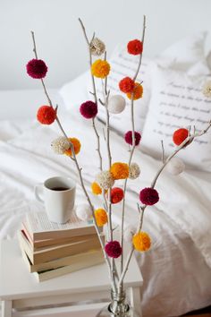 a vase filled with colorful pom - poms next to a book