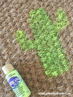 a bottle of deodorant next to a cactus on a rug with grass