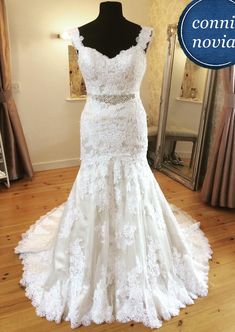 a wedding dress on display in front of a mirror with the words commie noias above it