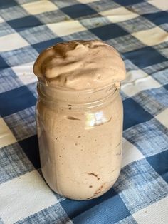 a jar filled with some kind of food on top of a checkered table cloth