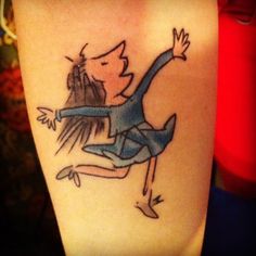 a woman's leg with a cartoon character tattoo on her left thigh and an arrow in the middle